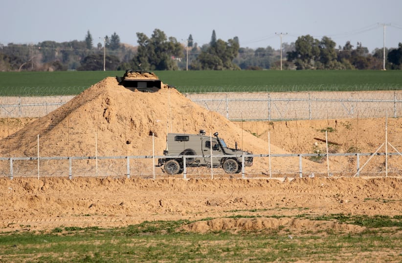 An Israeli military vehicle is seen at the Israel-Gaza border fence in the southern Gaza Strip, February 28, 2020 (photo credit: REUTERS/IBRAHEEM ABU MUSTAFA)