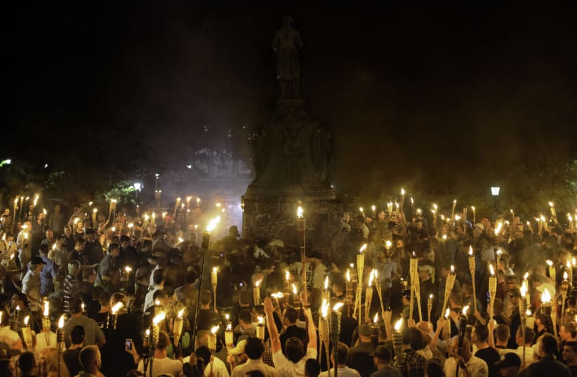 Neo-Nazis and white supremacists encircle counterprotesters at the base of a statue of Thomas Jefferson after marching through the University of Virginia campus with torches in Charlottesville, Va., Aug. 11, 2017 (photo credit: SHAY HORSE/NURPHOTO VIA GETTY IMAGES/JTA)