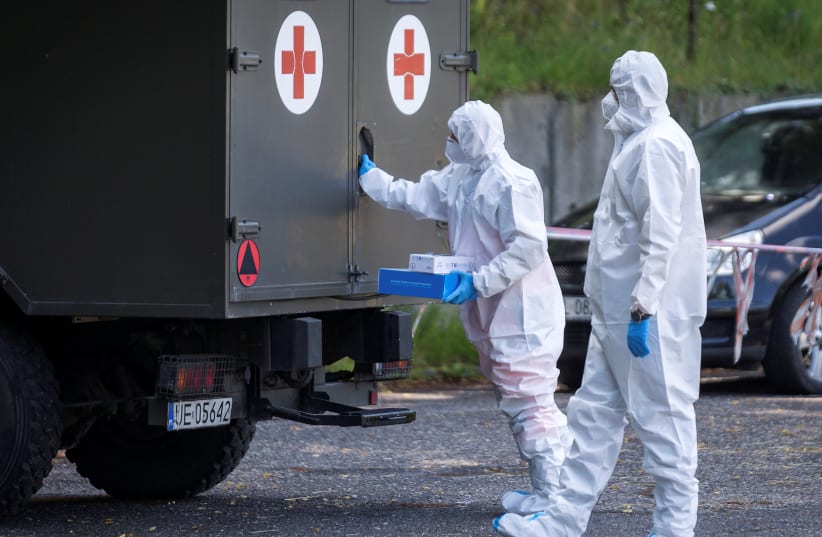 Health workers wearing protective gear are seen at a mobile testing station for miners of the Bielszowice coal mine, following the coronavirus disease (COVID-19) outbreak in Ruda Slaska, Poland July 27, 2020. (photo credit: REUTERS)