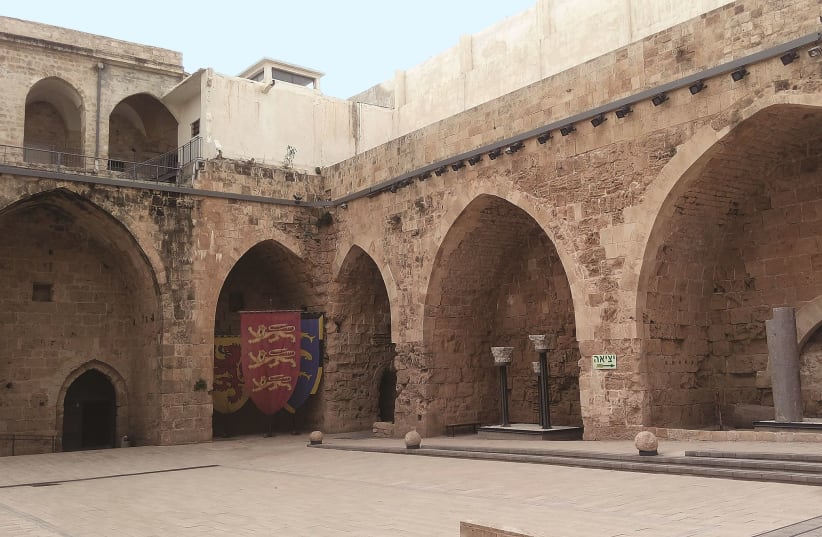 The courtyard of the Crusader-period Knights’ Fortress in Acre’s Old City, with the Ottoman buildings and British prison above. (photo credit: LIAT COLLINS)