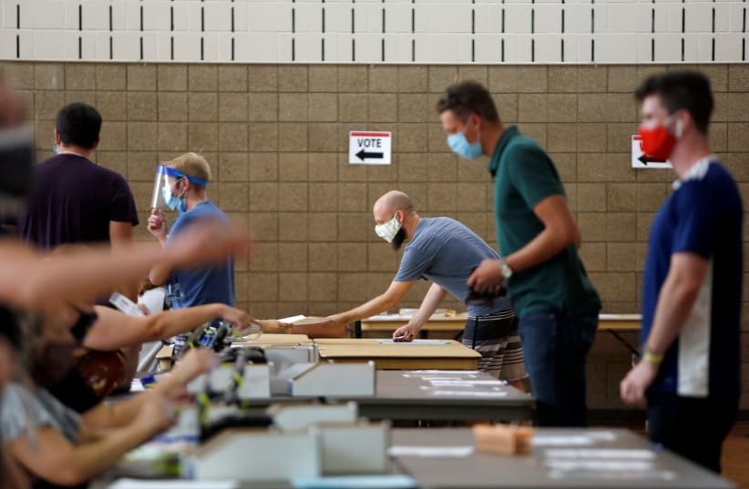 Voters check in at Whittier Community Center during the primary election in Minneapolis, Minnesota, U.S. August 11, 2020. (photo credit: REUTERS/NICOLE NERI)
