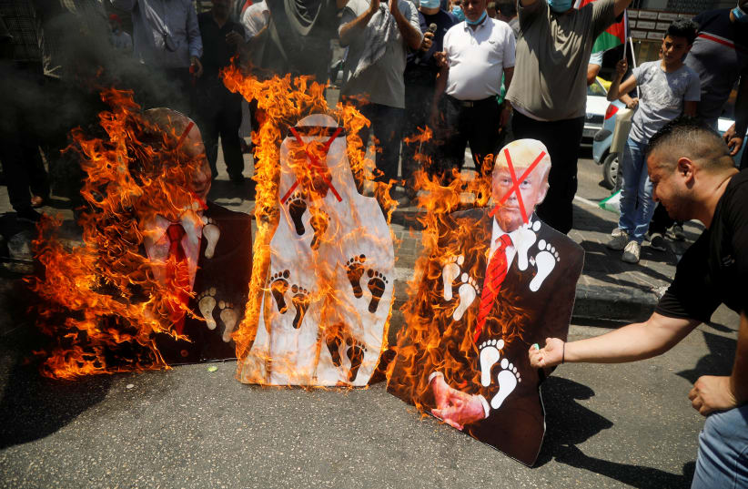 Palestinians burn cutouts depicting US President Donald Trump and Abu Dhabi Crown Prince Mohammed bin Zayed al-Nahyan and Israeli Prime Minister Benjamin Netanyahu during a protest against the United Arab Emirates' deal with Israel to normalise relations, in Nablus in the West Bank August 14, 2020. (photo credit: REUTERS/RANEEN SAWAFTA)