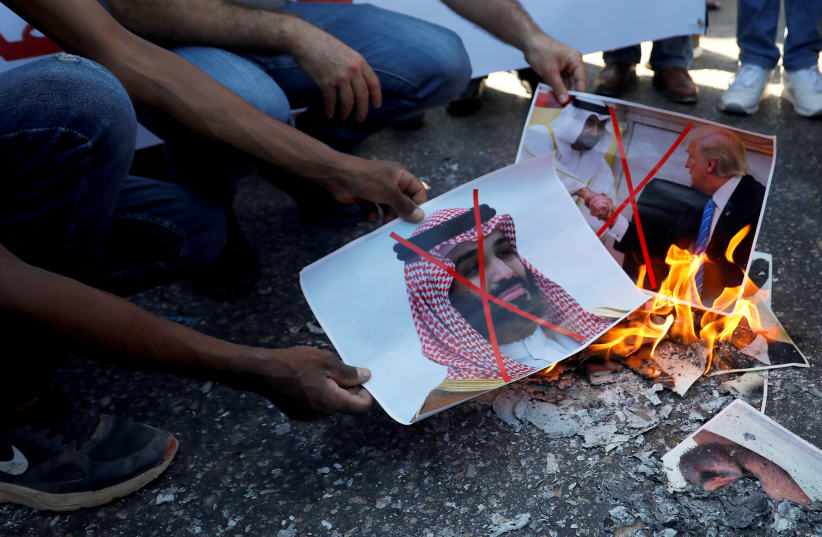 Palestinians burn pictures depicting U.S. President Donald Trump, Abu Dhabi Crown Prince Mohammed bin Zayed al-Nahyan and Saudi Arabia's Crown Prince Mohammed bin Salman during a protest against the United Arab Emirates' deal with Israel to normalise relations, in Ramallah in the West Bank August 15 (photo credit: REUTERS/MOHAMAD TOROKMAN)