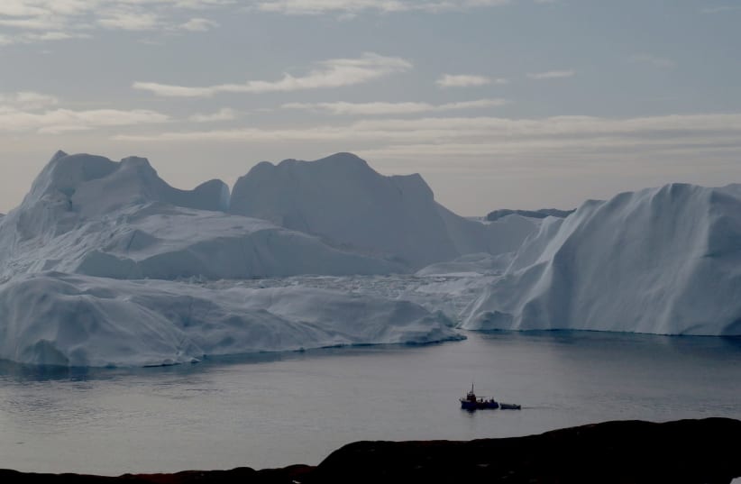 A fishing vessel sails in the ice fjord near Ilulissat, Greenland September 12, 2017 (photo credit: REUTERS/JACOB GRONHOLT-PEDERSEN/FILE PHOTO)