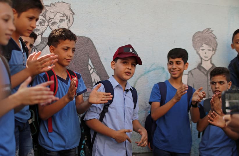 Abdel-Rahman Al-Shantti, an 11-year-old Gaza rapper, is surrounded by students as he performs in his school in Gaza City August 16, 2020.  (photo credit: MOHAMMED SALEM/REUTERS)