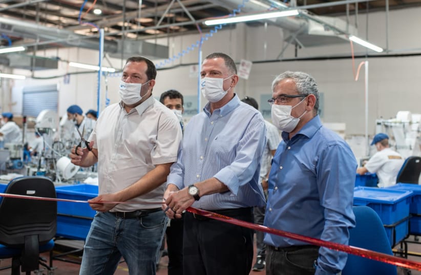 Health Minister Yuli Edelstein tours the Supergum factory in the West Bank, which makes masks, on August 18, 2020 (photo credit: OR KAPLAN)