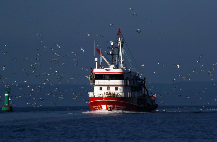 Seagulls fly over a fishing boat on the waters of the North Aegean Sea off the shores of Balikesir (photo credit: UMIT BEKTAS / REUTERS)