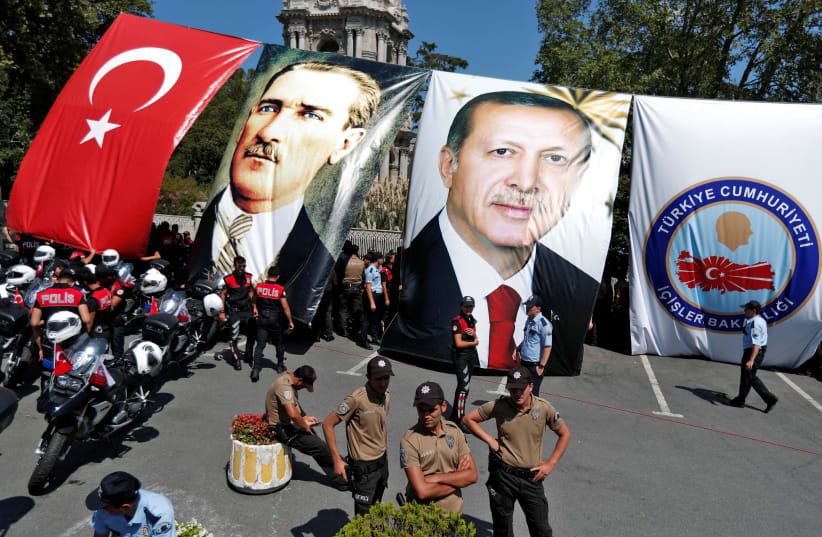 NEIGHBORHOOD GUARD members await the arrival of Turkish President Recep Tayyip Erdogan during a 2017 Istanbul ceremony. Posters of Erdogan (right) and modern Turkey’s founder Ataturk seen in background (photo credit: MURAD SEZER/REUTERS)