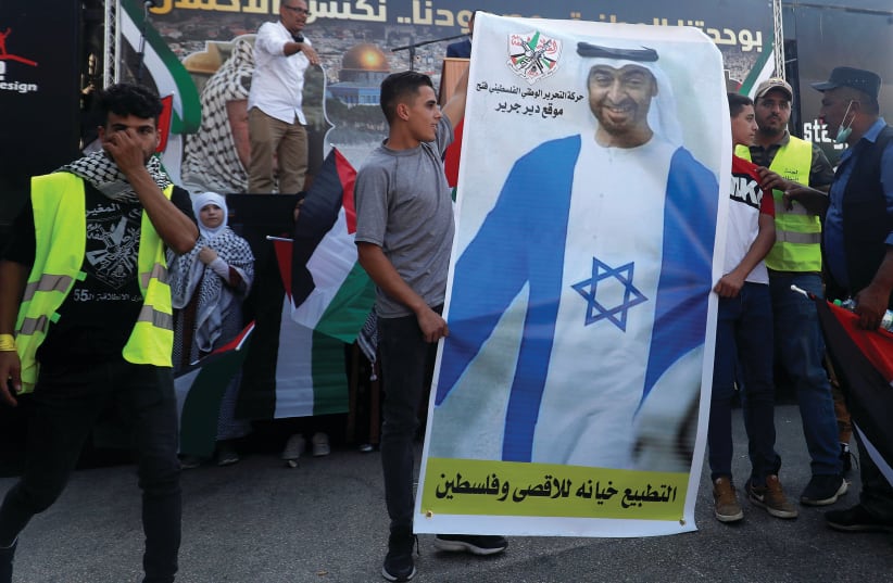 PALESTINIANS HOLD a picture depicting Abu Dhabi Crown Prince Mohammed bin Zayed al-Nahyan wearing a Jewish star during a protest against the UAE normalizing relations with Israel, in Turmus Aiya near Ramallah, on Wednesday. (photo credit: MOHAMAD TOROKMAN/REUTERS)