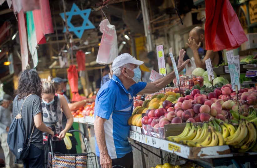 Israelis wear protective face masks as they shop for food at the Carmel market in Tel Aviv on August 12, 2020 (photo credit: MIRIAM ALSTER/FLASH90)
