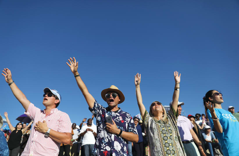 EVANGELICAL CHRISTIAN pilgrims and tourists reach for the sky at a 2019 religious retreat in Nazareth (photo credit: AMMAR AWAD/REUTERS)