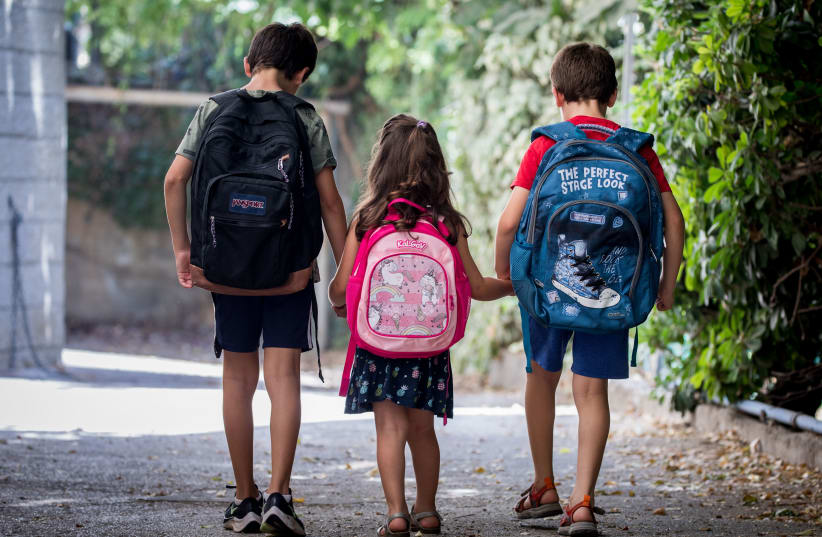 Israeli kids wearing school bags ahead of the first day of school and kindergarten outside their home in Jerusalem on August 31, 2020, The Israeli secular state education system will open tomorrow.  (photo credit: YONATAN SINDEL/FLASH90)