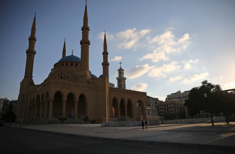 People walk along an empty street near al-Amin mosque, as Lebanon imposed a partial lockdown for two weeks starting on Friday in an effort to counter the spread of the coronavirus disease (COVID-19) which have spiralled since the catastrophic explosion at Beirut port, Lebanon August 21, 2020 (photo credit: REUTERS/ALKIS KONSTANTINIDIS)