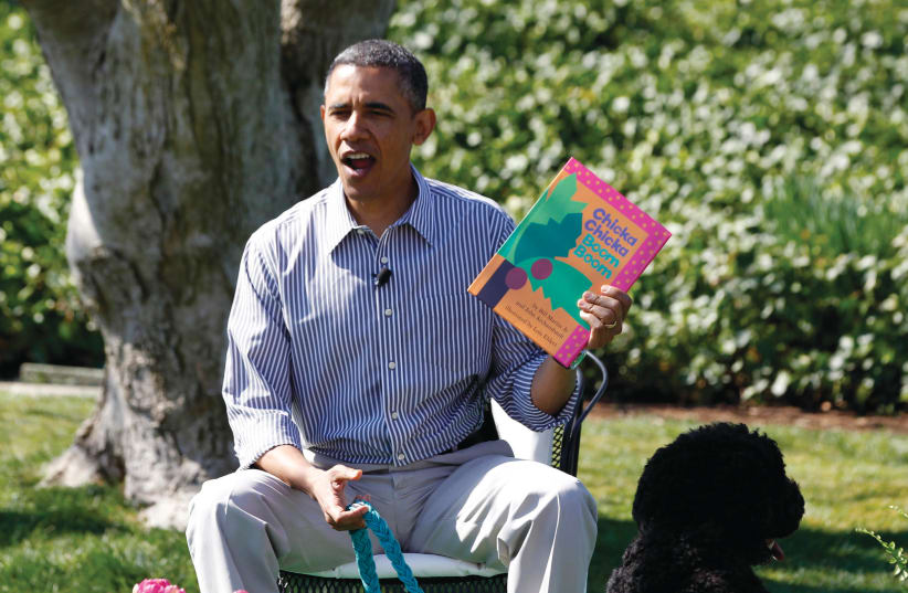 THEN-PRESIDENT Barack Obama reads to children alongside his faithful companion, dog Bo, during the White House Easter Egg Roll in 2013 (photo credit: JASON REED/REUTERS)