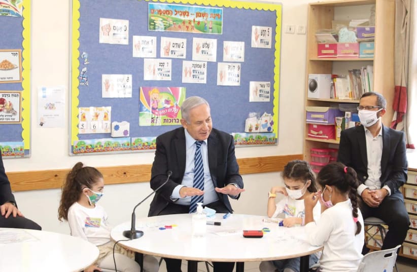 PRIME MINISTER Benjamin Netanyahu explains what a virus is to first graders in the West Bank settlement of Mevo Horon. (photo credit: MARC ISRAEL SELLEM/THE JERUSALEM POST)