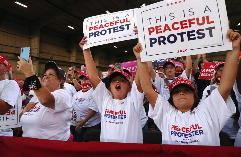 Supporters hold signs as U.S. President Donald Trump delivers a campaign speech at Arnold Palmer Regional Airport in Latrobe, Pennsylvania, U.S., September 3, 2020.  (photo credit: LEAH MILLIS/REUTERS)
