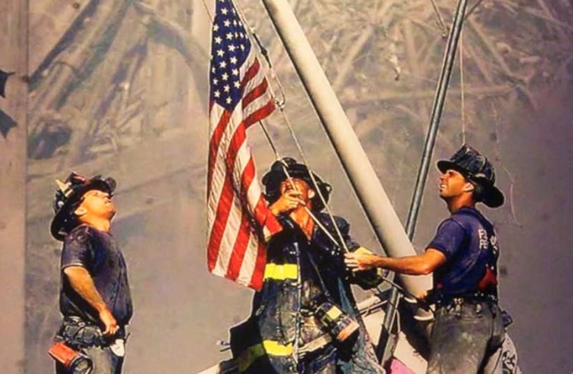 ‘Raising the Flag at Ground Zero’ is a photograph by Thomas E. Franklin of ‘The Record’ taken on September 11, 2001. The picture shows three New York City firefighters raising the US flag at Ground Zero of the World Trade Center following the 9/11 attacks (photo credit: THOMAS E. FRANKLIN)