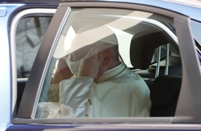 Pope Francis puts on a protective face mask as he enters the car after holding the weekly general audience, at the Vatican September 9, 2020. (photo credit: REMO CASILLI/ REUTERS)