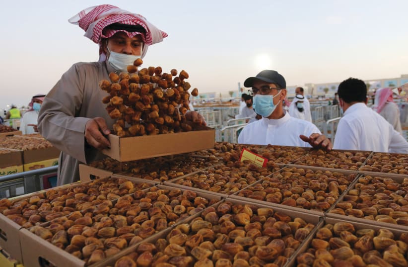 STAYING LOCAL: A Saudi farmer displays dates to customers during Unaizah Season for Dates, in Saudi Arabia on August 15 (photo credit: AHMED YOSRI/ REUTERS)