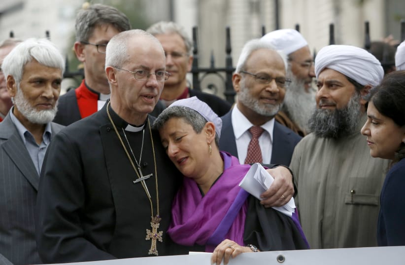 Rabbi Laura Janner-Klausner (center) joins a vigil against human rights violations in Iraq outside Westminster Abbey with the Archbishop of Canterbury, Justin Welby (second from left), Imam Shaykh Ibrahim Mogra (second from right) and Sayeeda Warsi (right) in 2014 (photo credit: REUTERS)
