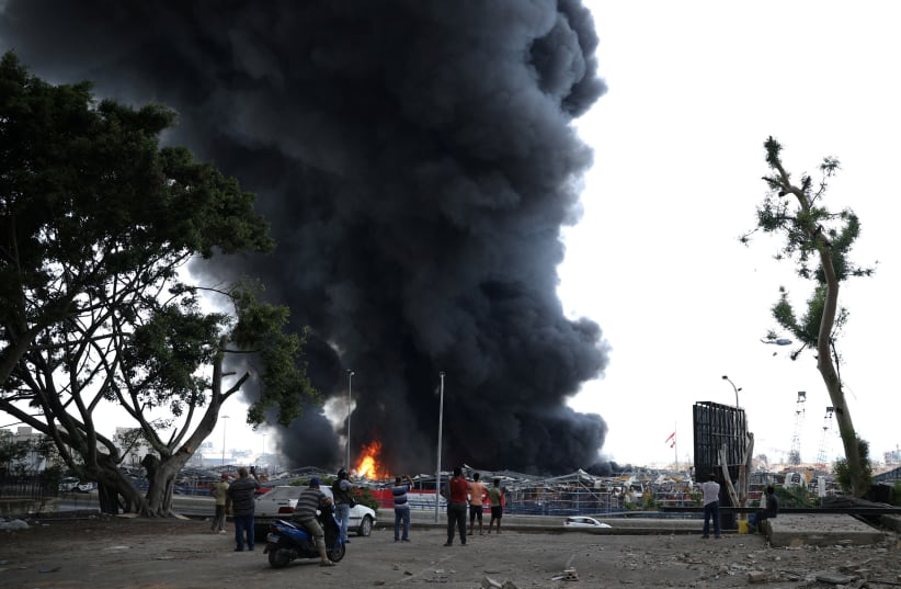 People stand as smoke rises after a fire broke out at Beirut's port area, Lebanon September 10, 2020. (photo credit: REUTERS/EMMA FREIHA)