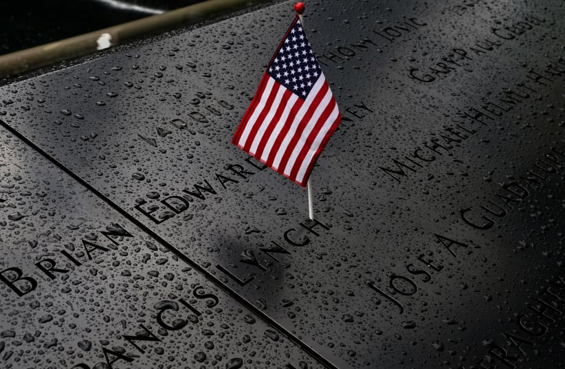 Rain drops rest near a US flag at the south reflecting pool at the National 9/11 Memorial the day before the 19th anniversary of the 9/11 attacks, New York City, September 10, 2020. (photo credit: REUTERS/CARLO ALLEGRI)