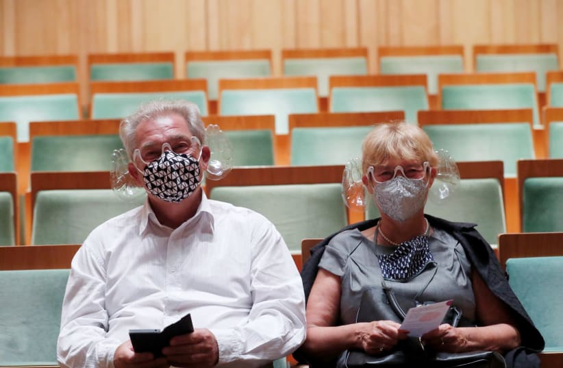 A couple wears orchestra conductor Ivan Fischer's acoustic mask at the Mupa Budapest in Budapest, Hungary, September 11, 2020 (photo credit: REUTERS/BERNADETT SZABO)