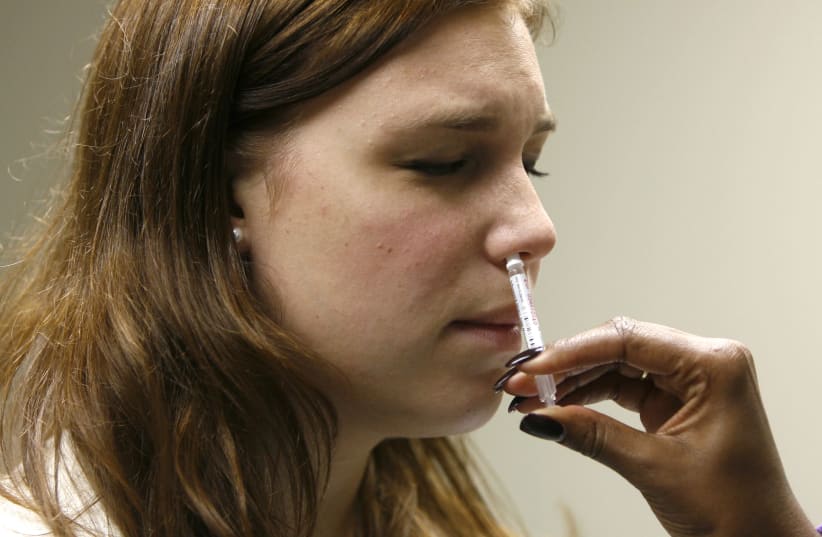 George Washington University student Jessica Hirsh is given the H1N1 flu nasal spray vaccine at the Student Health Service clinic in Washington, November 19, 2009 (photo credit: REUTERS/HYUNGWON KANG)