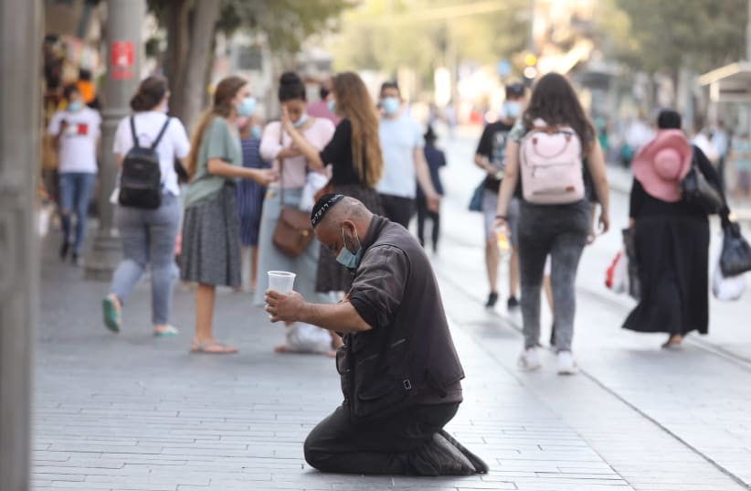 A beggar sits and asks for money amid the coronavirus crisis, Jerusalem, 2020 (photo credit: MARC ISRAEL SELLEM)
