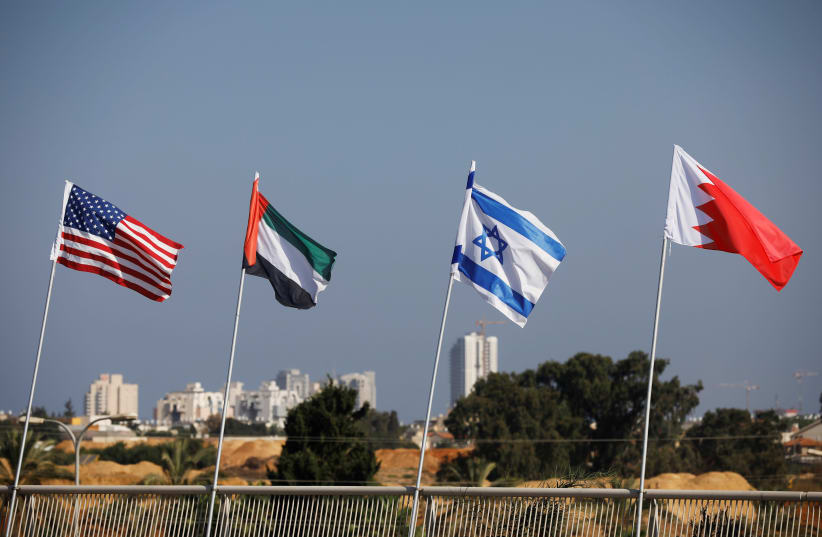 The flags of the U.S., United Arab Emirates, Israel and Bahrain flutter along a road in Netanya (photo credit: NIR ELIAS / REUTERS)