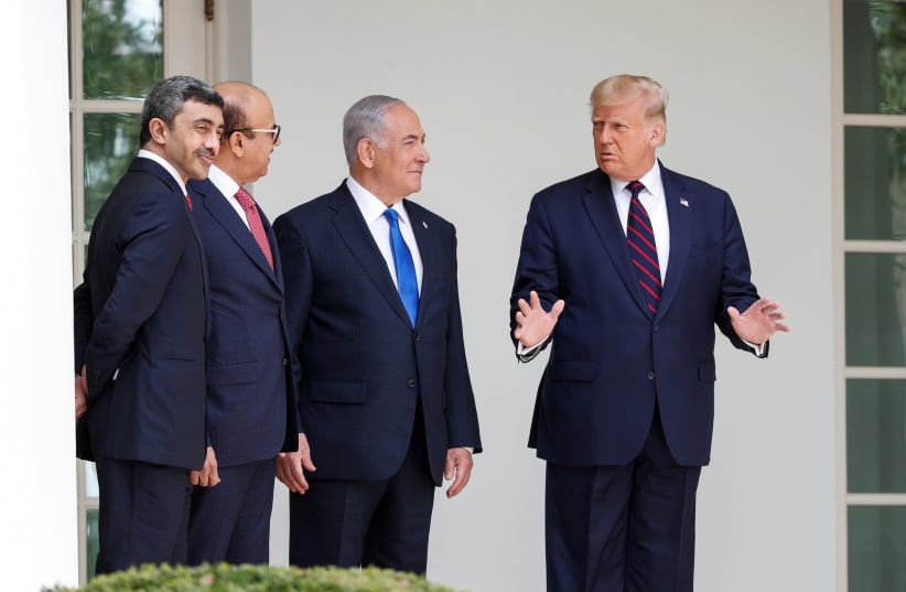 U.S. President Donald Trump speaks United Arab Emirates (UAE) Foreign Minister Abdullah bin Zayed, Bahrain’s Foreign Minister Abdullatif Al Zayani and Israel's Prime Minister Benjamin Netanyahu prior to signing the Abraham Accords, normalizing relations between Israel and some of its Middle East nei (photo credit: REUTERS/TOM BRENNER)