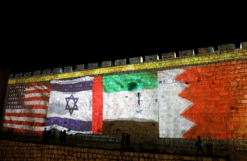 The flags of the United States, Israel, United Arab Emirates and Bahrain are projected on a section of the walls surrounding Jerusalem's Old City. September 15, 2020 (photo credit: RONEN ZVULUN / REUTERS)