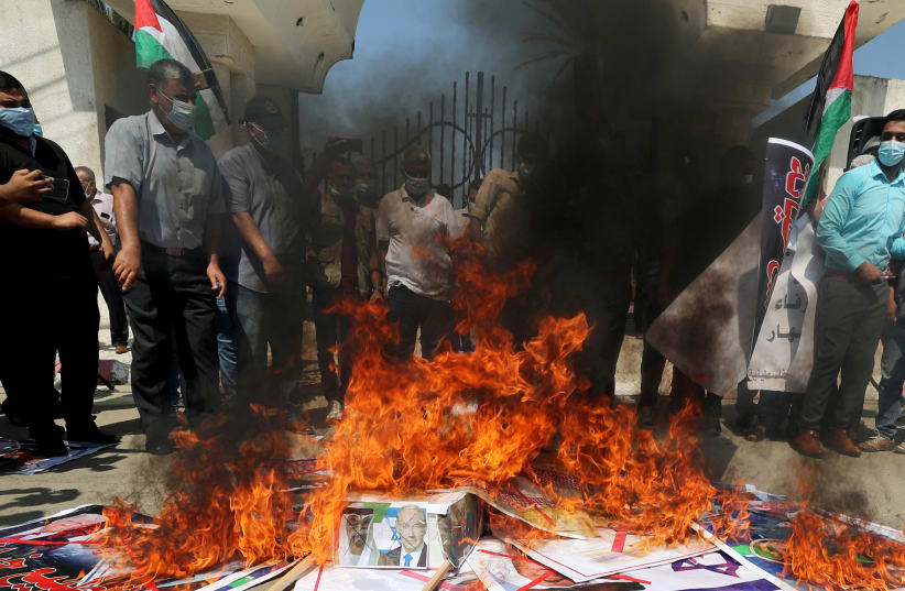 Palestinians burn pictures depicting Abu Dhabi Crown Prince Mohammed bin Zayed al-Nahyan, Israeli Prime Minister Benjamin Netanyahu and U.S. President Donald Trump during a protest against the United Arab Emirates and Bahrain's deal with Israel to normalise relations, in Gaza City September 15, 2020 (photo credit: REUTERS/MOHAMMED SALEM)