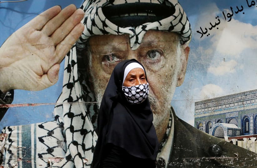 A woman passes a poster depicting late Palestinian leader Yasser Arafat, Shatila Palestinian refugee camp, Beirut (photo credit: MOHAMED AZAKIR / REUTERS)