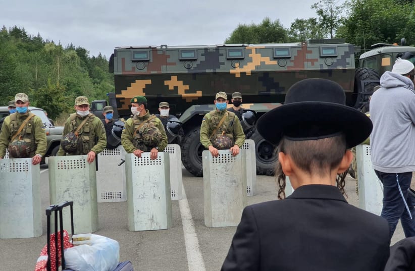 Jewish pilgrims, who plan to enter Ukraine from the territory of Belarus, gather in front of Ukrainian service members near Novi Yarylovychi crossing point in Chernihiv Region, Ukraine September 15, 2020 (photo credit: BRESLEV LIVE/HANDOUT VIA REUTERS)