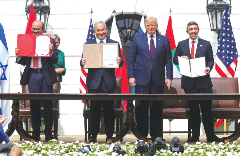 FROM LEFT: Bahrain’s Foreign Minister Abdullatif Al Zayani, Prime Minister Benjamin Netanyahu and United Arab Emirates Foreign Minister Abdullah bin Zayed display their copies of signed agreements, while US President Donald Trump looks on, as they participate in the signing ceremony of the Abraham A (photo credit: REUTERS//TOM BRENNER)