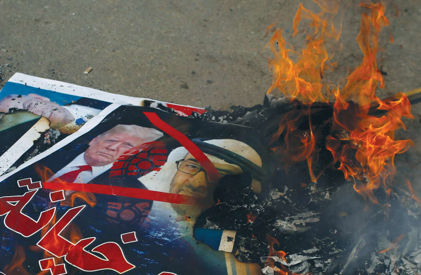 PICTURES DEPICTING Prime Minister Benjamin Netanyahu, US President Donald Trump and Abu Dhabi Crown Prince Mohammed bin Zayed al-Nahyan are burned by Palestinians during a protest against the United Arab Emirates’ and Bahrain’s deals with Israel to normalize relations, in Gaza City, Tuesday. (photo credit: MOHAMMED SALEM/ REUTERS)