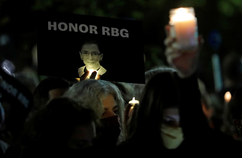 A sign with an image of late U.S. Supreme Court Justice Ruth Bader Ginsburg is displayed during a vigil following her death, outside the U.S. Supreme Court in Washington, U.S., September 19, 2020 (photo credit: REUTERS/YURI GRIPAS)