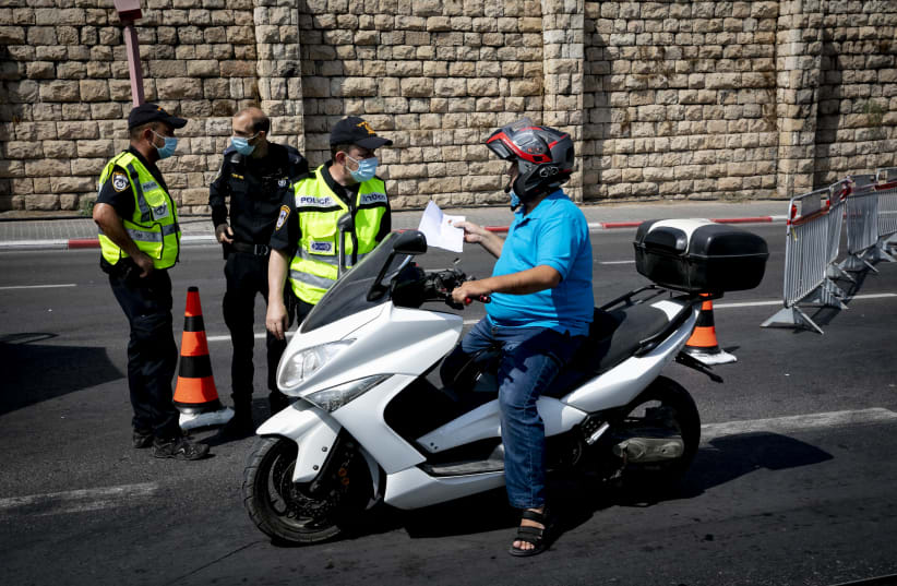 Israeli Police at a temporary "checkpoint"  on road 1 in  Jerusalem, on September 20, 2020. Israel has seen a spike of new COVID-19 cases bringing the authorities to reimpose a nationwide lockdown that begin on Friday and last at least three weeks.  (photo credit: OLIVIER FITOUSSI/FLASH90)
