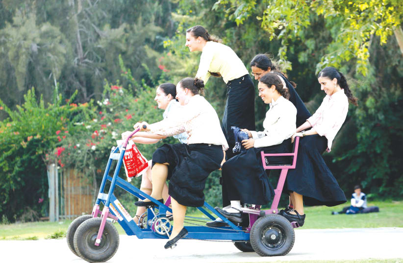 Young ultra-orthodox women ride through Hayarkon Park in Tel Aviv.  (photo credit: MOSHE SHAI/FLASH90)