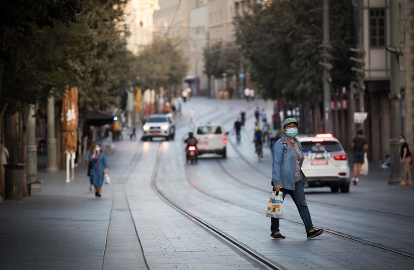 People walk next to closed shops on Jaffa Street in downtown Jerusalem on September 24, 2020, during a nationwide lockdown (photo credit: YONATHAN SINDEL/FLASH90)