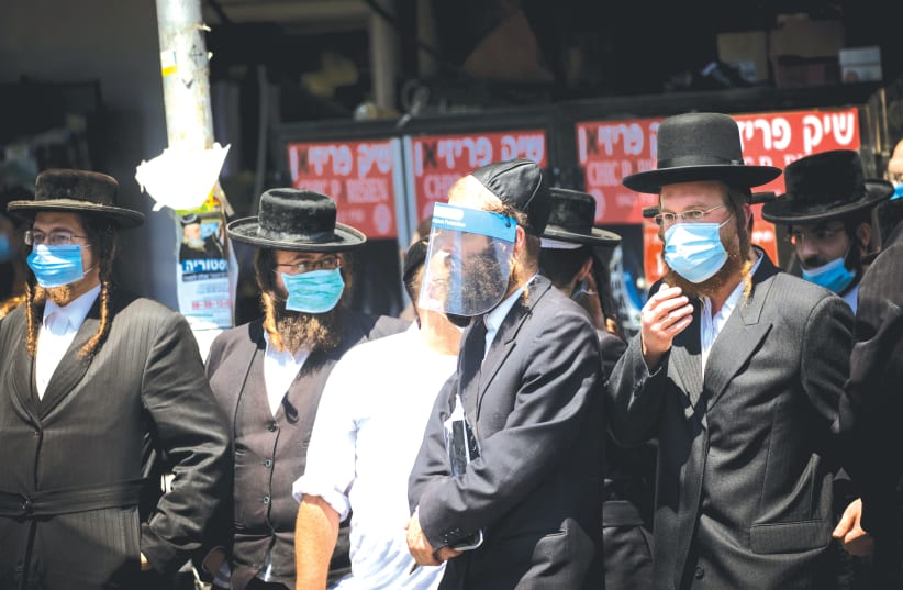 HAREDIM ON a Jerusalem street. Leading rabbis are asking ‘Does the death toll justify shutting down communal life?’  (photo credit: MARC ISRAEL SELLEM/THE JERUSALEM POST)