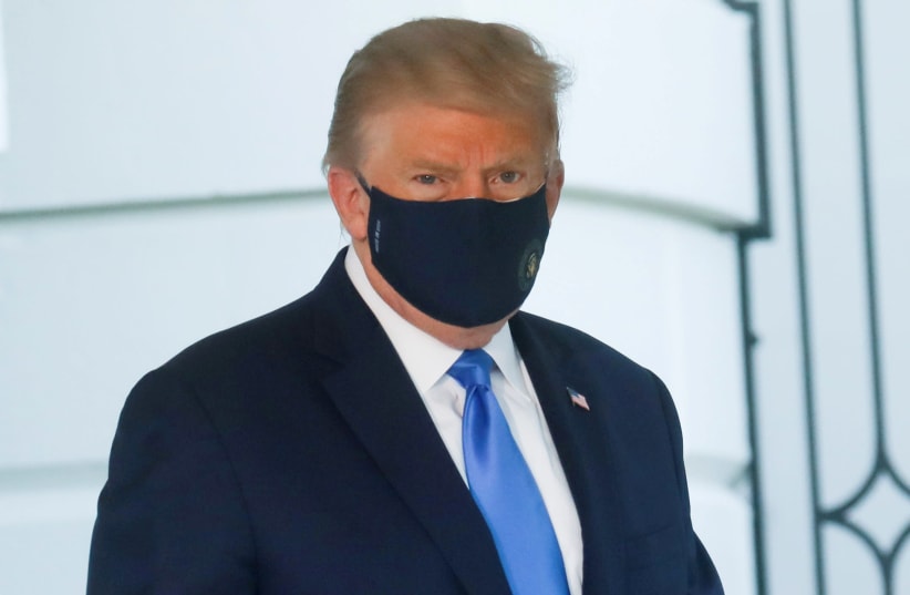 U.S. President Trump walks to the Marine One helicopter wearing a protective face mask as he departs the White House to fly to Walter Reed National Military Medical Center (photo credit: REUTERS/LEAH MILLIS)