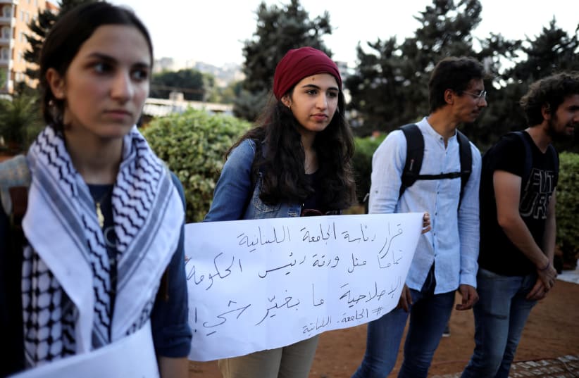 Zainab Sharaf al-Deen, 18, is seen holding a placard alongside others at an anti-government protest in Beirut, Lebanon, on October 22, 2019. (photo credit: ALKIS KONSTANTINIDIS / REUTERS)