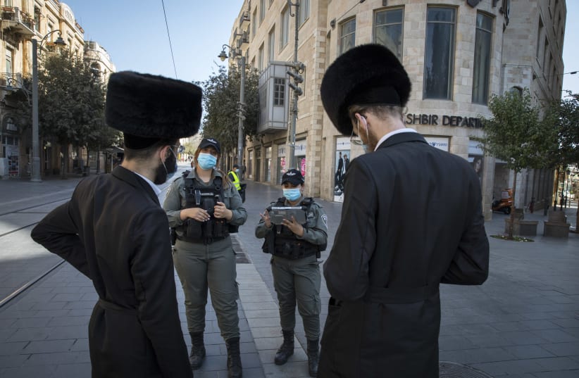 Israeli border police officers check citizens on Jaffa Street in downtown Jerusalem on October 7, 2020, during a nationwide lockdown to prevent the spread of COVID-19. (photo credit: NATI SHOHAT/FLASH90)