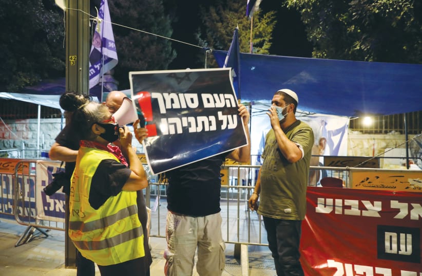 ISRAELIS HOLD A counter-protest in support of Benjamin Netanyahu close to a demonstration against him near the prime minister’s official residence in Jerusalem last week. The sign reads: ‘The people trust Netanyahu!’  (photo credit: MARC ISRAEL SELLEM/THE JERUSALEM POST)