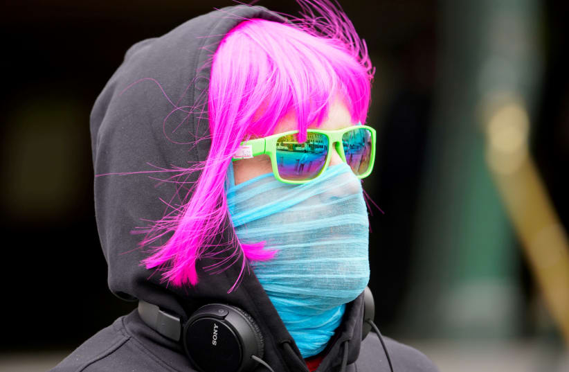 A person wears a scarf as a protective face mask in Melbourne, the first city in Australia to enforce mask-wearing in public, as part of efforts to curb a resurgence of the coronavirus disease, July 23, 2020. (photo credit: REUTERS/SANDRA SANDERS)