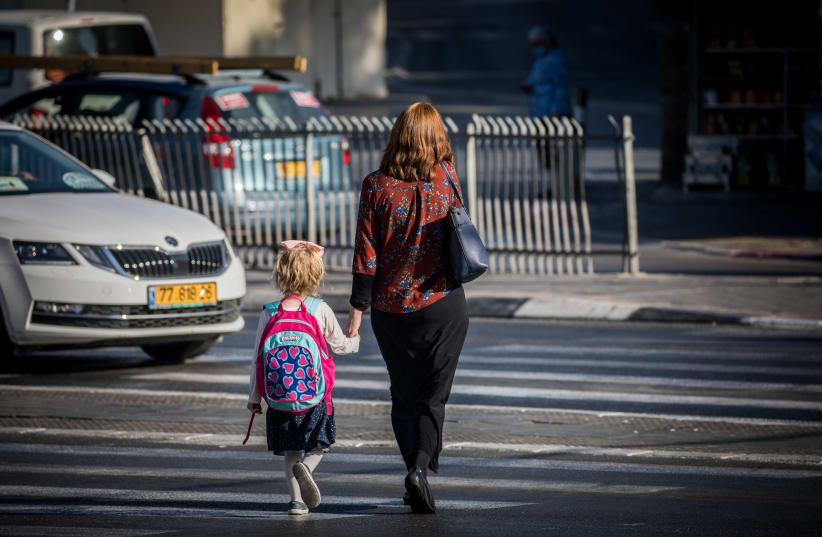 An ultra-Orthodox woman accompanies her daughter to school, Jerusalem, October 19, 2020 (photo credit: YONATAN SINDEL/FLASH90)