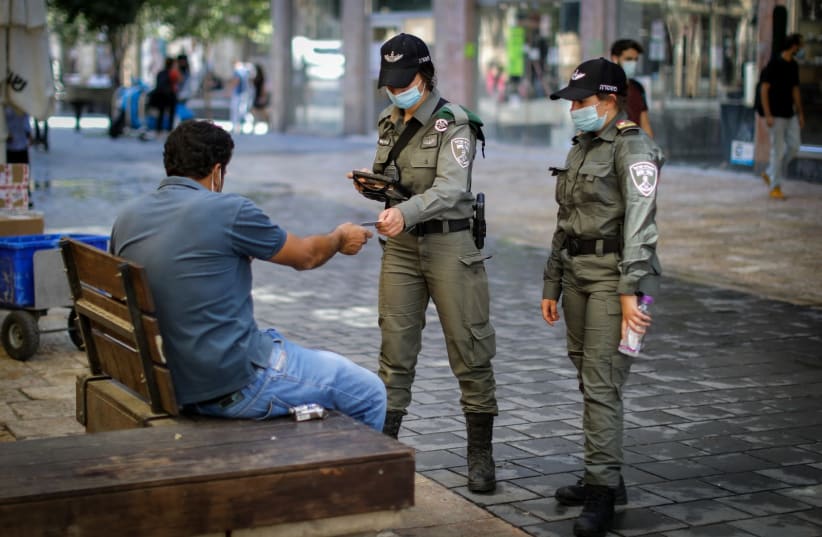 Israel Police officers check citizen's identification to keep coronavirus restricions, Jerusalem (photo credit: MARC ISRAEL SELLEM)