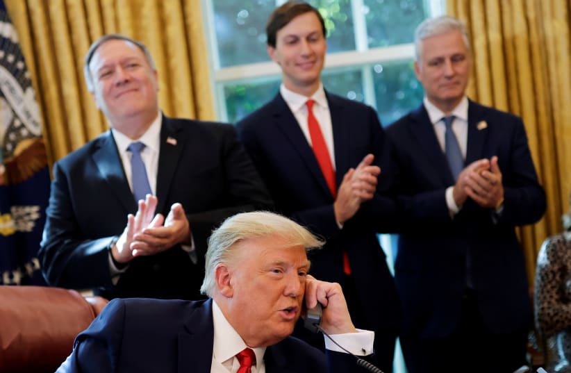 Secretary of State Mike Pompeo and White House senior advisor Jared Kushner applaud as US President Donald Trump is seen on the phone with leaders of Israel and Sudan, in the Oval Office at the White House in Washington, October 23, 2020. (photo credit: CARLOS BARRIA / REUTERS)